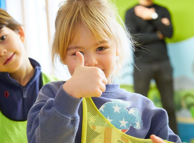 Blondes Mädchen zeigt Daumen nach oben.