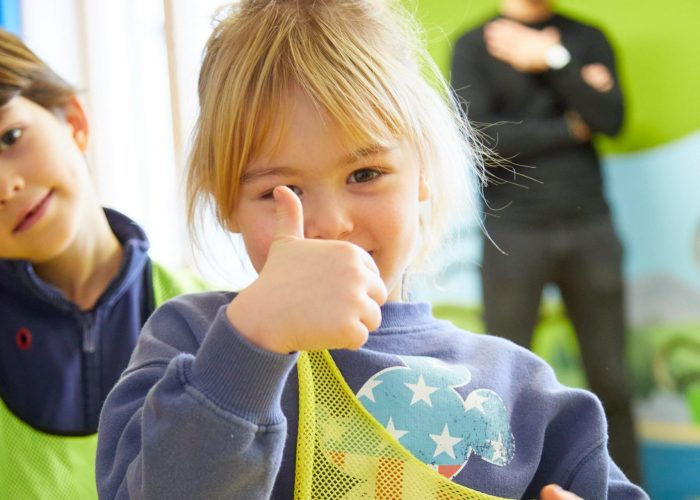 Blondes Mädchen zeigt Daumen nach oben.