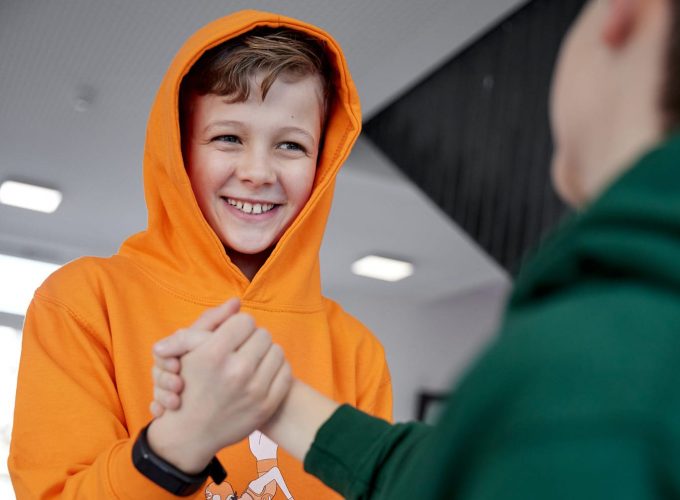 Zwei Jungen geben sich einen Handschlag.