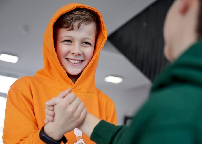 Zwei Jungen geben sich einen Handschlag.