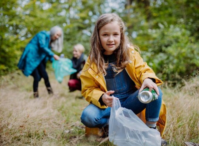 Personen in der Natur sammeln Müll auf.