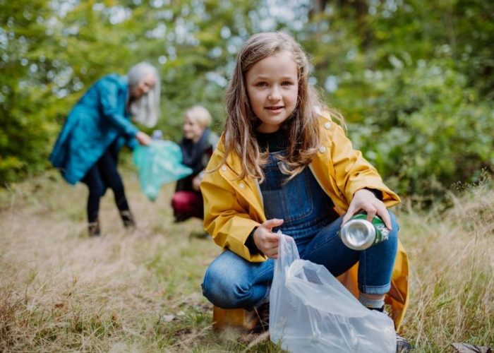 Personen in der Natur sammeln Müll auf.